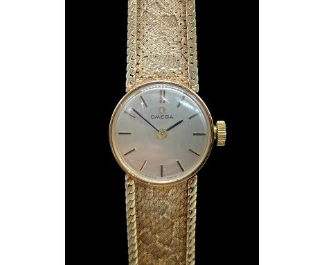 OMEGA; a lady's vintage 9ct gold wristwatch, with baton markers to the circular dial and integral textured bracelet, length 1