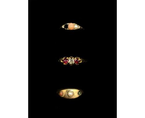 A yellow metal cabochon bead set ring (one stone missing), a yellow metal diamond and ruby three stone ring, size N, and a ye