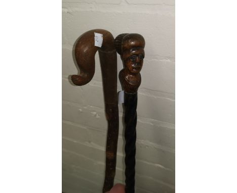 A novelty walking stick with facemask terminal; a crook; a gilt mirror 