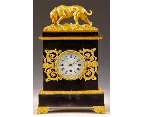 A late 19th Century Regency style gilded and blued Metal MANTEL CLOCK&nbsp;with cast dog surmount above scrolled side pieces 