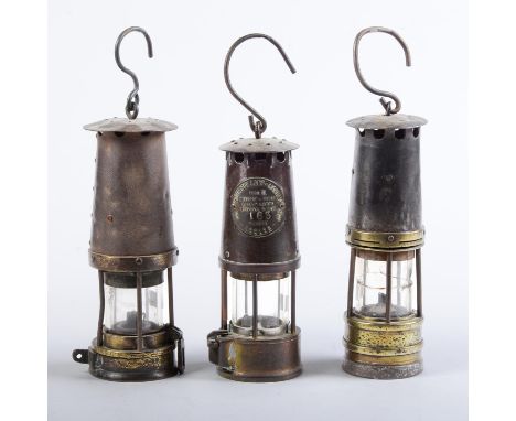 Three brass&nbsp; and ferrous metal miner's safety lamps, late 19th and early 20th c, two unmarked, one by the Protector Lamp