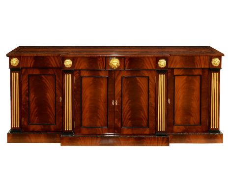 A parcel gilt mahogany breakfront sideboard in Regency style, by R &amp; D Davidson, London, applied with lion masks above fl
