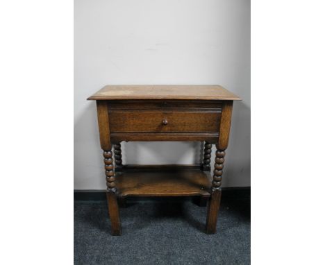 An early 20th century oak fall fronted side table on bobbin legs 