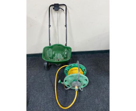 A Hoselock hose pipe on reel together with a garden seed spreader 