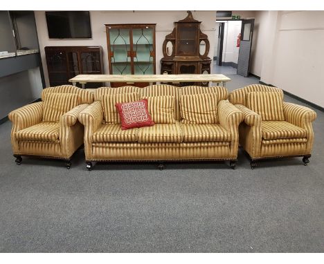 An Edwardian three piece lounge suite upholstered in golden striped fabric, width of sofa 205 cm 