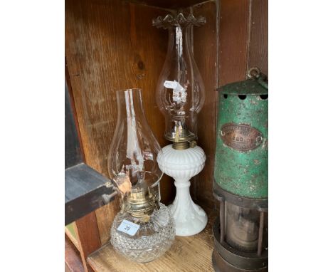 A milk glass lamp with brass fitting and funnel together with a cut glass lamp with funnel. 