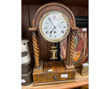 A vintage clock, with enamelled face, on twist columns, with low tray and key. 
