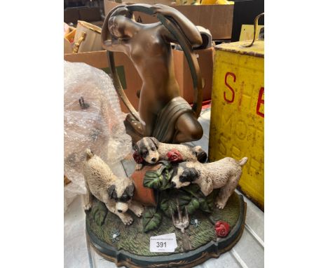 A metal door stop depicting puppies and an Art Deco plaster figure of a semi-nude lady. 