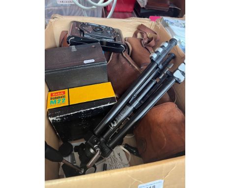 A box containing vintage cameras and accessories. 