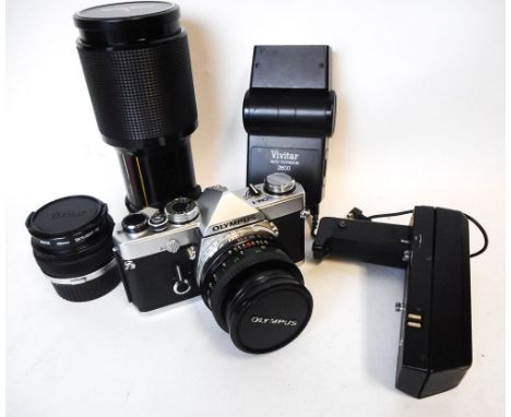 An Olympus OM-1 MD,35mm camera,: with wide angle lens, telephoto lens, standard lens, camera grip, Mf-1 OM adapter, contained