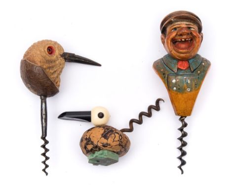A painted carved wood corkscrew of a laughing man:, together with a carved bird's head example and another abstract bird cork