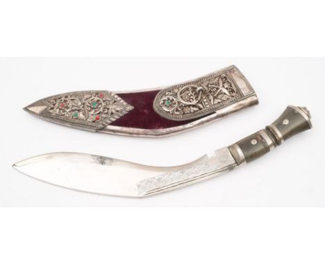 A kukri in a white metal mounted presentation scabbard:, of traditional form with stipple decorated blade and horn handle, th