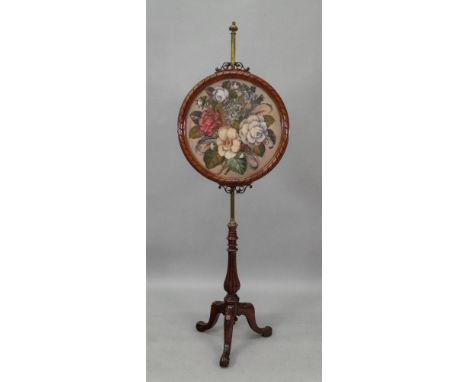 A Victorian carved walnut pole screen, with adjustable cylindrical brass column, the glazed oval banner with a plush, beaded 