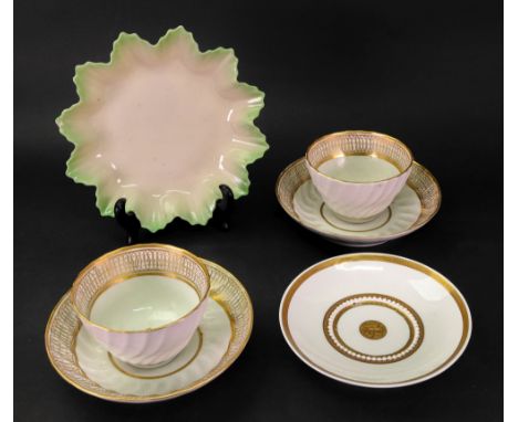 A pair of English tea bowls and saucers circa 1790, moulded with curved lobes and flutes and gilded, the saucers 14cm diamete