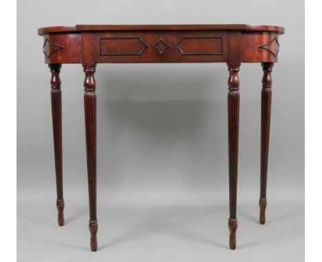 A reproduction Regency style mahogany and ebonised console table, of break bowfront outline, with frieze drawer, on turned an