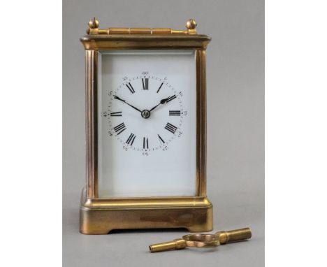 A French brass cased carriage timepiece, the white enamel dial with Roman numerals, 18cm high, with key.
