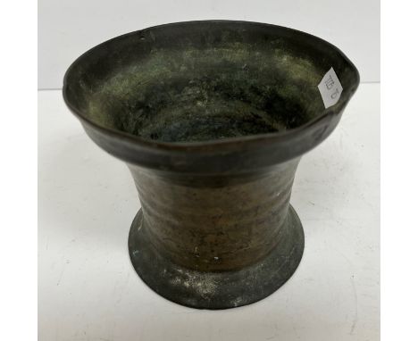 A 17th Century bronze mortar of plain form, the flared rim over a shallow ribbed body raised on a flared foot 12.7 cm diamete