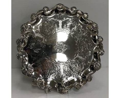 A Victorian silver salver in the Rococo taste with all-over engraved decoration of shells and flowers within scrolling foliag