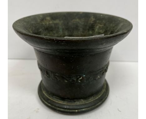 A 17th Century bronze mortar of plain form, the flared rim over a foliate banded main body raised on a reeded foot 14.6 cm di