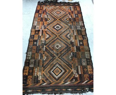 A Kelim carpet, the central panel set with four repeating diamond medallions in orange, brown, blue and red etc within a step