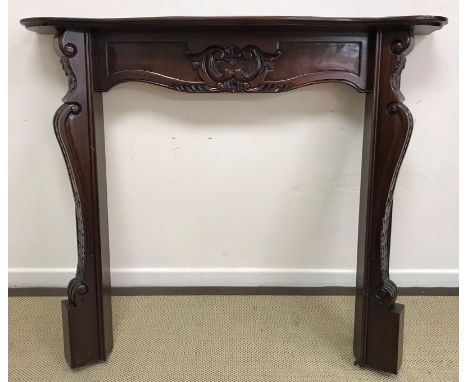 A modern mahogany fire surround with carved foliate decoration in the 19th Century manner 136 cm wide x 122.5 cm high togethe