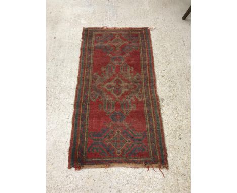 A Donegal runner, the central panel set with repeating medallion design on a red ground within a stepped red, blue and green 