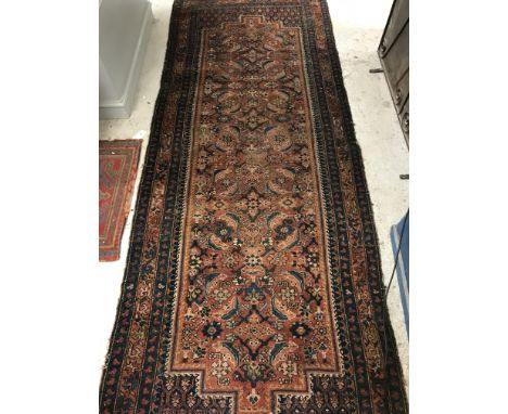 A Persian runner, the central panel set with repeating stylised foliate sprays on a red ground within a stepped red and blue 