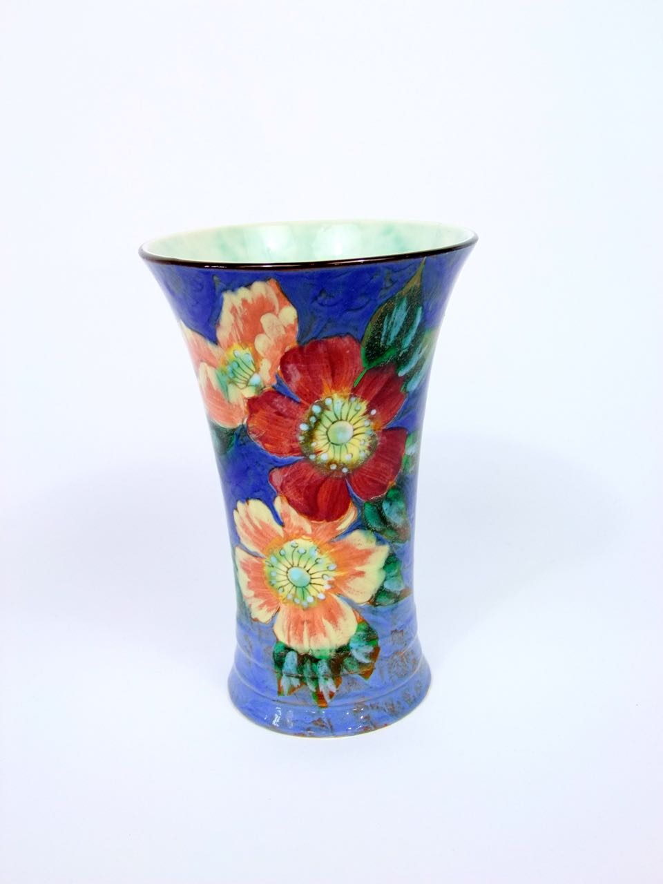 A Royal Doulton blue ground vase of flared form with polychrome painted