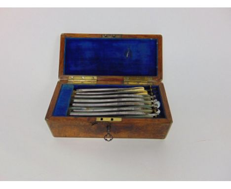 A  19th century brass band walnut box comprising a collection of pearl handled cut throat razors, some marked with the days o