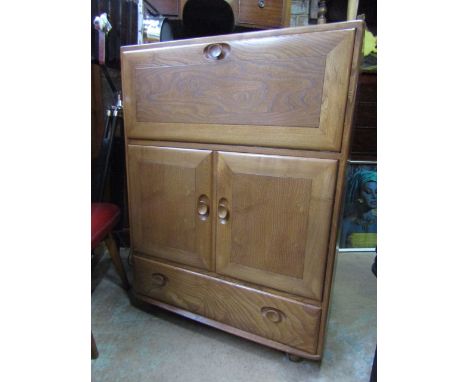 An Ercol light elm bureau with full front door over two cupboard doors and single long drawer.