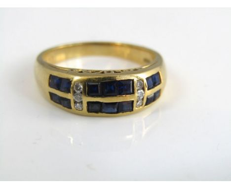 An 18ct sapphire and diamond ring with two rows of square cut sapphires separated into three sections by diamonds, size M, 4g