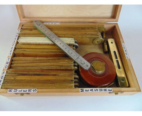 A box containing a large collection of articulated rulers and measuring tools together with spirit levels and others.