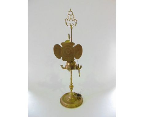An interesting eastern brass oil lamp fitted with a screen and revolving globular sconce holder, 92 cm high approx. 