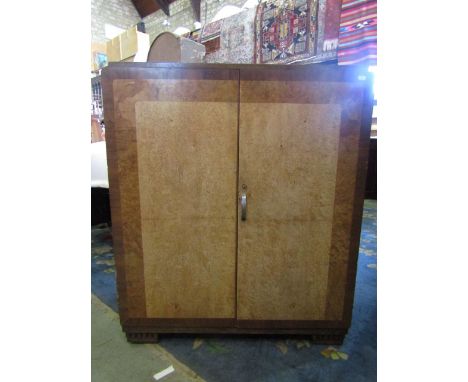 An Art Deco figured maple and walnut linen cupboard, the doors enclosing three sliding shelves and a further shelf with chrom