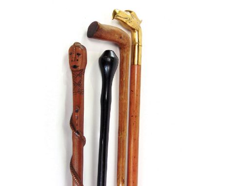 Four various walking sticks to include one with cast eagle knop, another with snake trailing up the shaft, a further heavy cu