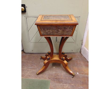 A good quality Regency teapoy in faded rosewood, the sarcophagus shaped caddy with fitted interior, the panels simulating fig