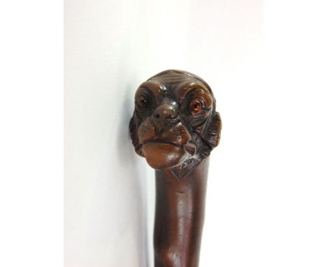 A walking stick with carved gorilla head knop with glass eyes and silver collar.