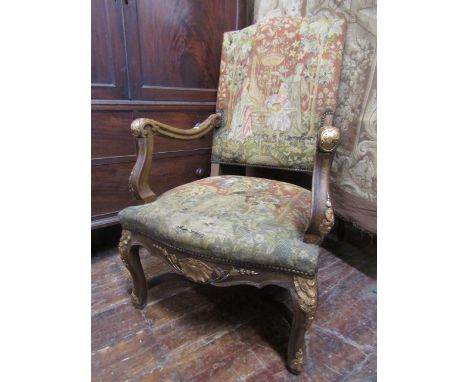 A late 19th century open elbow chair with hand worked medieval style tapestry seat and back, the framework with gilded detail
