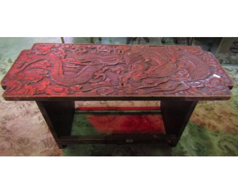 A Chinese red lacquered occasional table of rectangular form with dragons, clouds and pearl detail, 90 cm in length