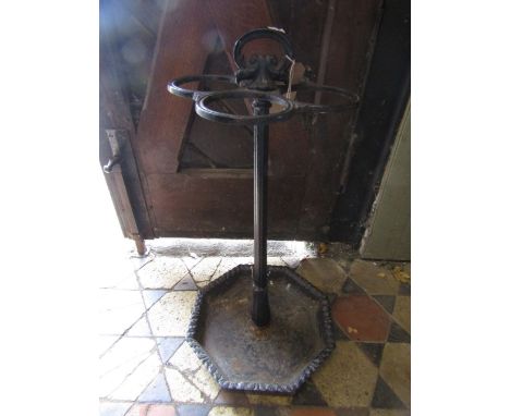 A Victorian cast iron stick stand with octagonal drip tray, central collar and four ring support with carrying handle