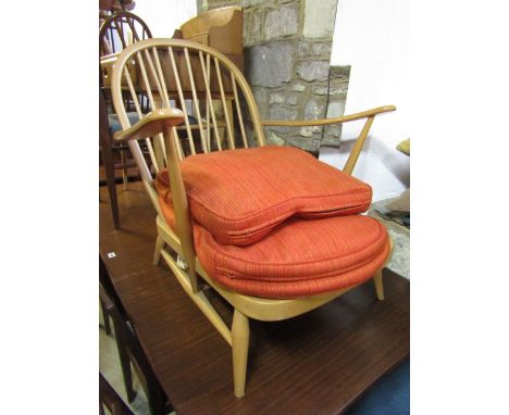 An Ercol light elm lounge chair with stick back and burnt orange upholstery.