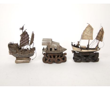Three various Chinese silver ships, two upon carved wooden bases