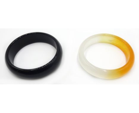 Yellow and ice colour jade bangle and a black agate bangle