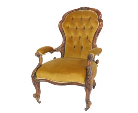 A Victorian walnut open armchair, with button back, upholstered in gold coloured Draylon, on cabriole legs with castors.