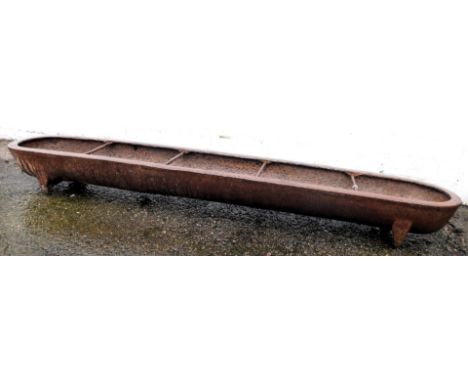 A cast iron pig trough or animal feeder, 151cm wide. 