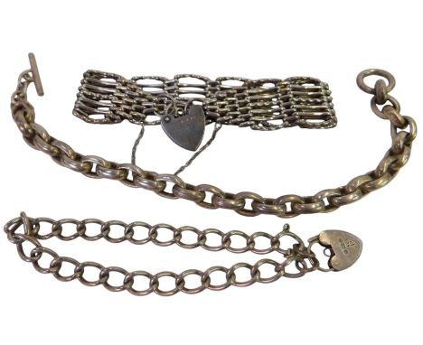 Three silver bracelets, comprising a five-bar gate bracelet on a heart-shaped padlock clasp, an oval link bracelet with a rin