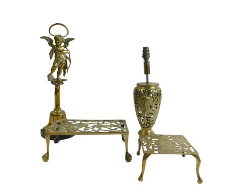 A group of brassware, comprising two pierced metal trivets, one decorated with swallows and the other with a heraldic crest, 