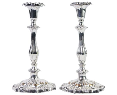 A pair of Victorian silver plated candlesticks, decorated with shell and scrolling motifs, loaded, 26cm high.