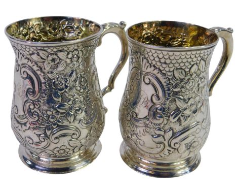 A pair of George III silver tankards, each profusely embossed with flowers, scrolls and leaves, with an initialled cartouche,