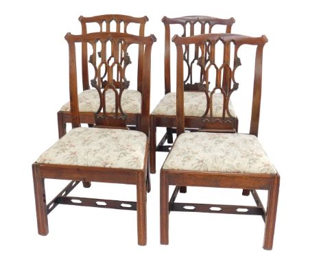 A set of four George III mahogany dining chairs, in Chippendale style, each with scroll carved ears, a pierced Gothic style s